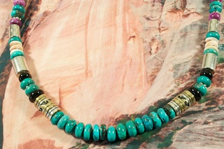Stunning Necklace featuring Genuine Turquoise with Sugilite, Black Onyx, Spiny Oyster Shell and Tiger's Eye Accents. Sterling Silver and Gold Fill Barrels. Sterling Silver Barrels, Beads, Cones and Clasp. Created by Navajo Artist Tommy Singer. Signed by the artist.